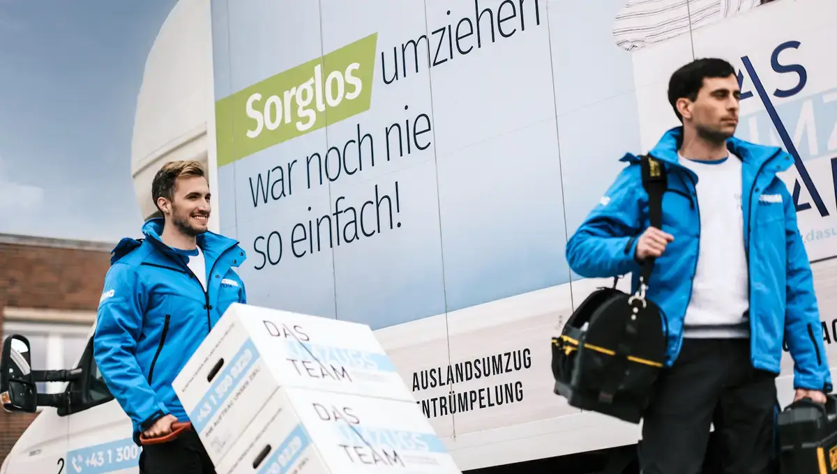 KFZ-Ummeldung-beim-Umzug 2 Möbelpacker stehen vor einem Umzugswagen
