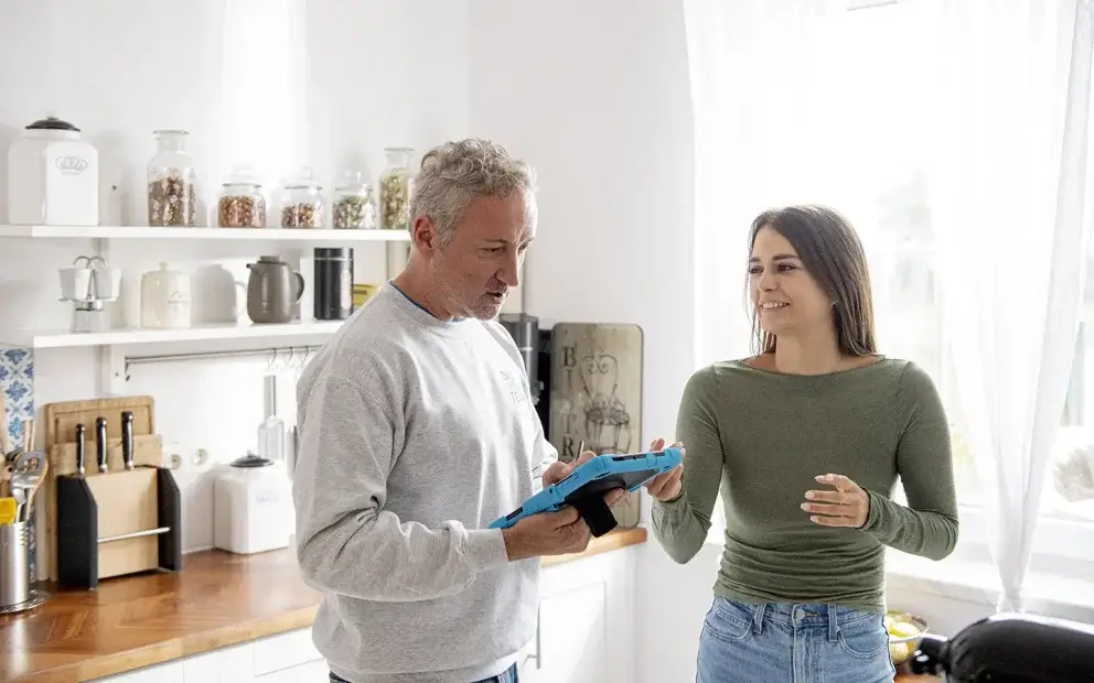 Man und Frau stehen in einer Küche planen einen Umzug.