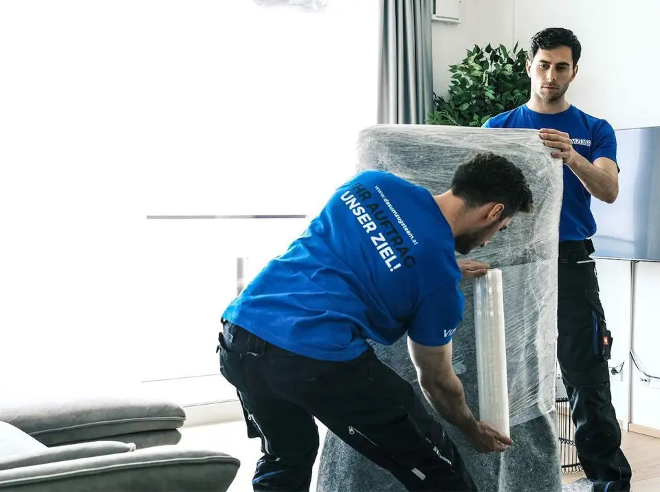 2 Männer verpacken ein schweres Sofa