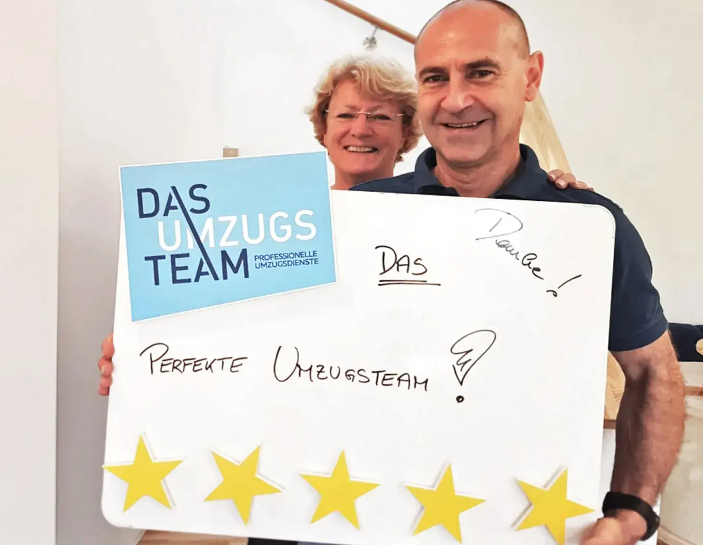 Ein Ehepaar steht mit Bewertungstafel mit 5 Sternen in der Hand da.