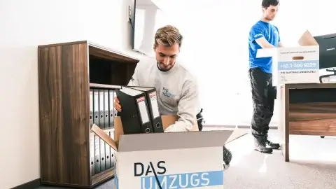 Firmenumzug: Zwei junge Möbelpacker räumen ein Büro aus
