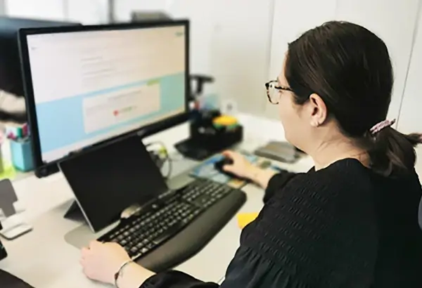 Mitarbeiterin von DasUmzugsteam erstellt am Computer ein Umzugsangebot