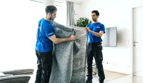 Möbelpacker verpacken einen Kasten