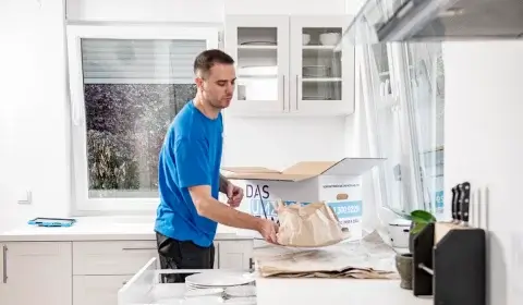 Umzug Traun: Umzugshelfer verpackt Geschirr